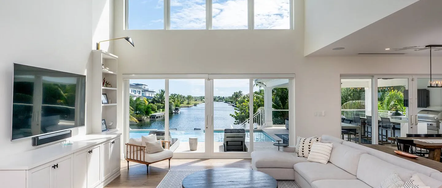 The vertical windows allow natural light to seamlessly flow into the living room. Outdoors you look towards the canal over your own private pool.