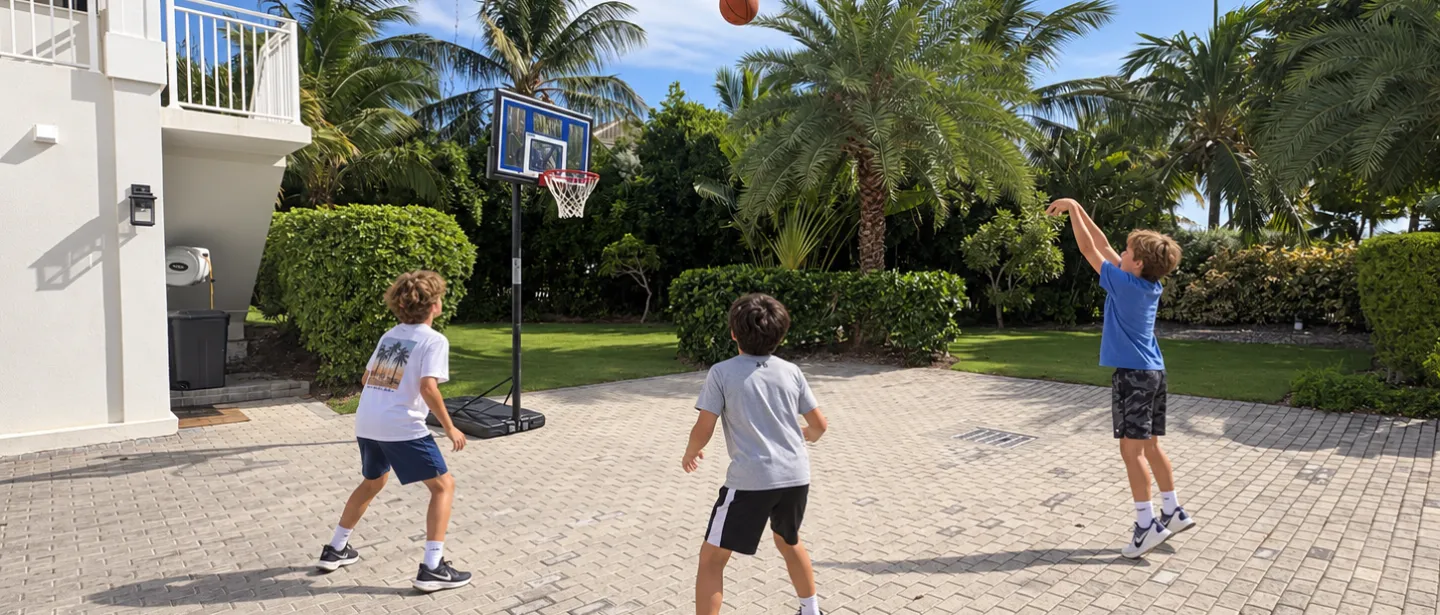 Sunny tropical driveway court with basketball hoop and family-friendly space.