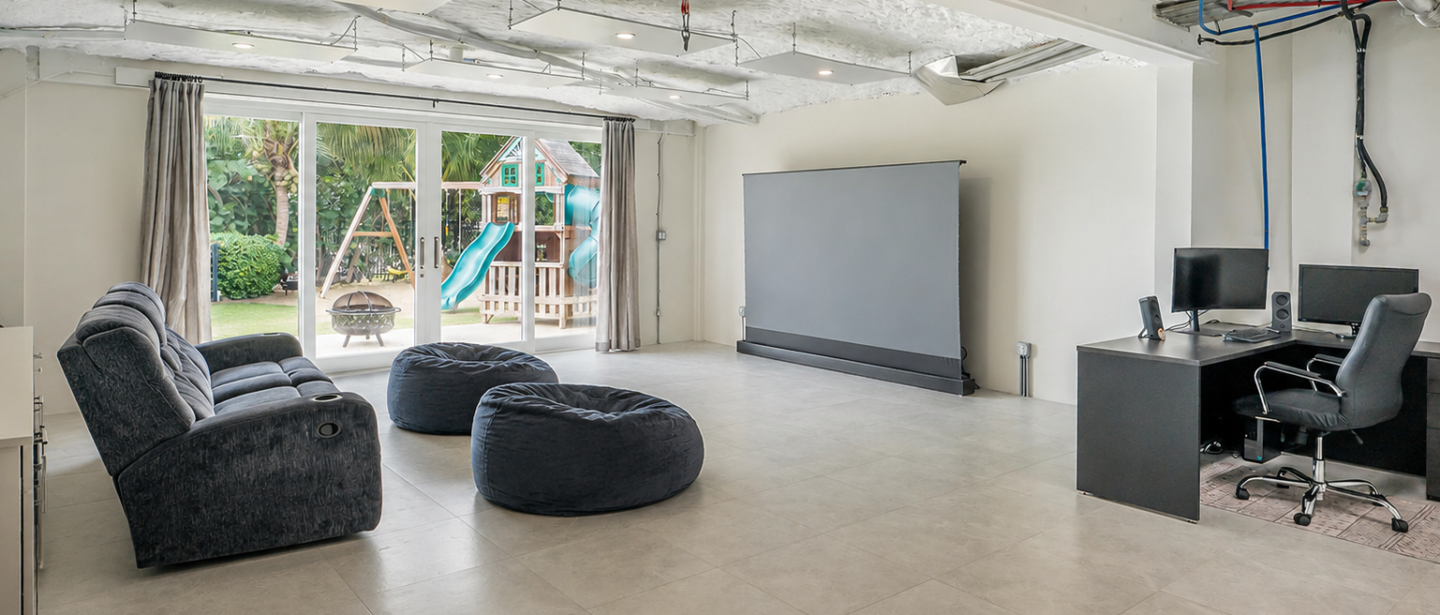 Spacious entertainment room with projector, workspace, and garden access