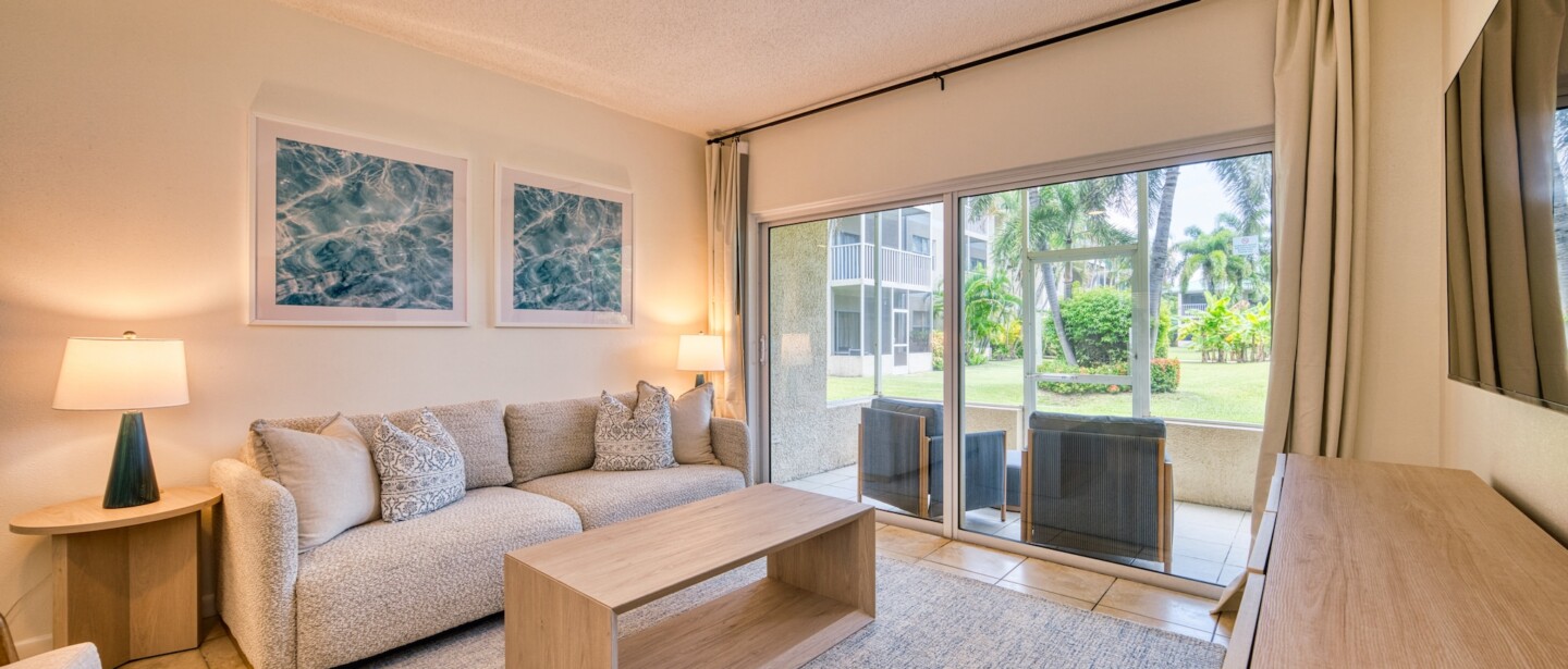 Bright garden-view living room with private patio and cozy modern seating