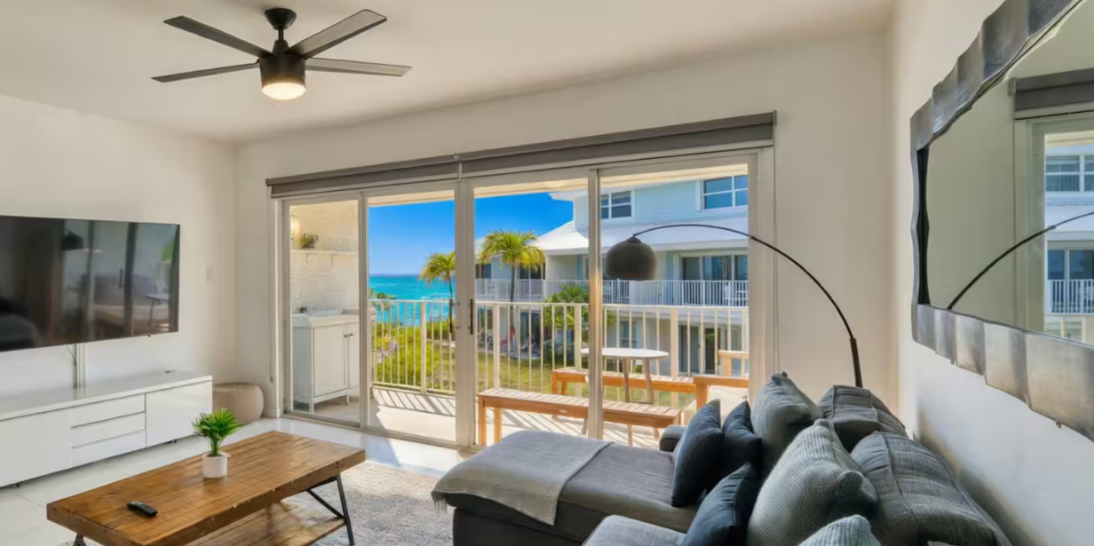 Bright coastal living room with balcony seating and ocean views