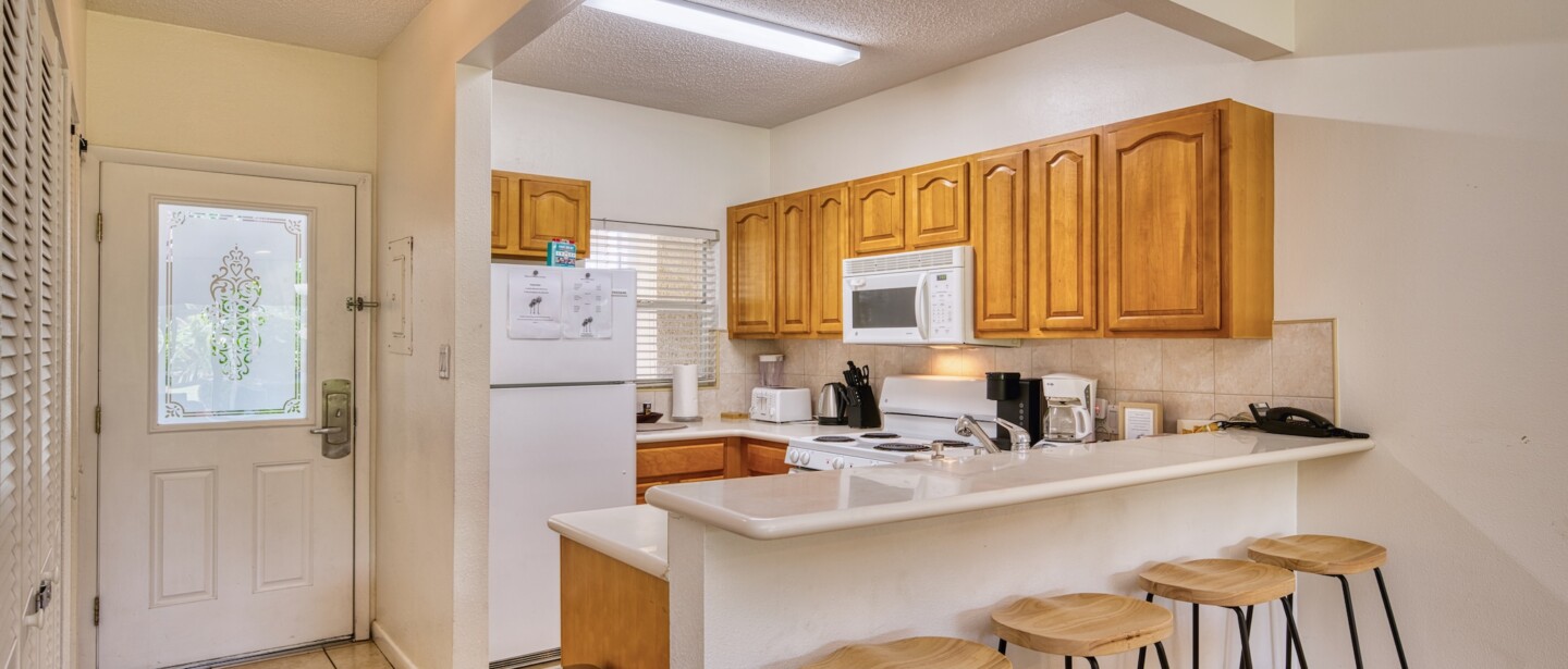 Bright kitchen with breakfast bar seating for four and full-size appliances