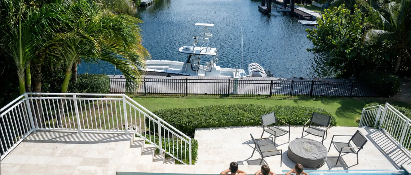 Private waterfront pool deck with canal views and boat dock access.