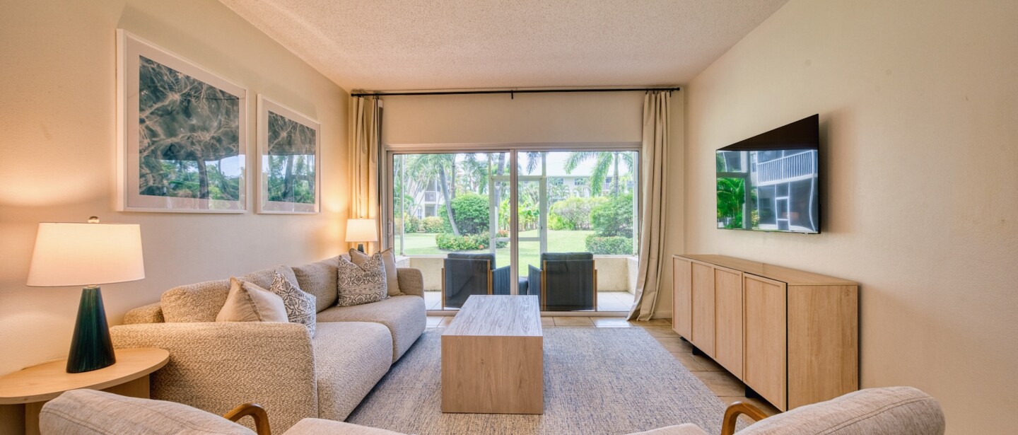 Bright tropical living room with patio access and serene garden views